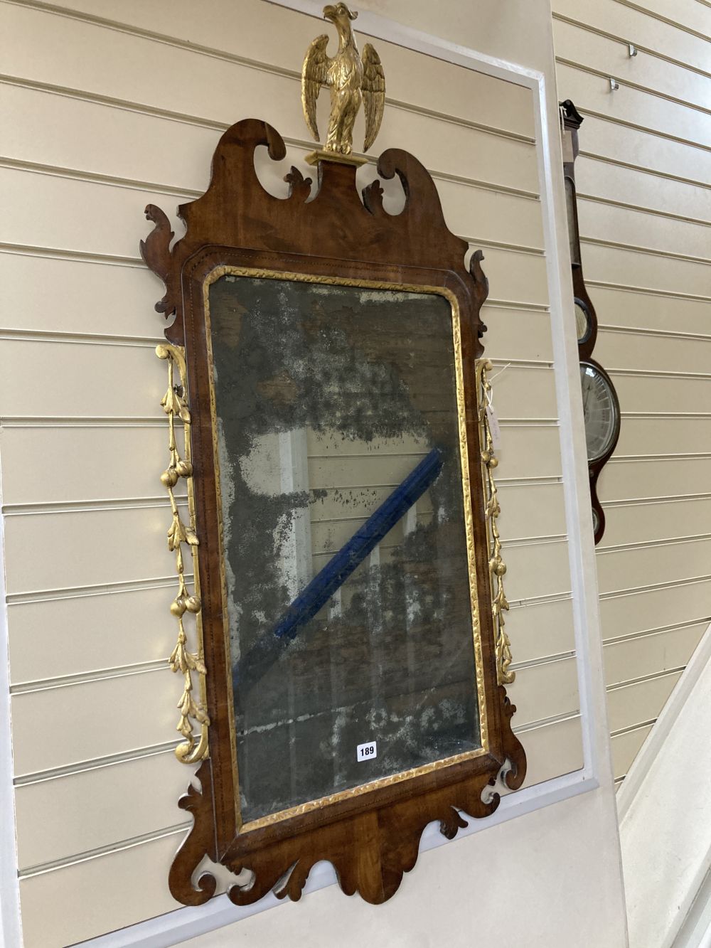 A George II parcel gilt walnut fret cut wall mirror, width 56cm height 120cm