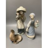 Two Lladro porcelain figures and a Royal Copenhagen model of a seal, tallest 26cm