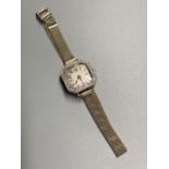 A lady's 1930's white metal and diamond bezel set manual wind wrist watch, on an 18ct mesh link