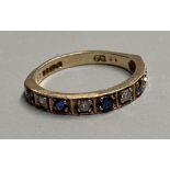 A modern 9ct gold, sapphire and diamond set nine stone half hoop ring, size L, gross 2.3 grams.