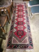 A Caucasian design red ground runner, 290 x 76cm