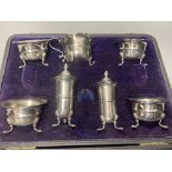 An Edwardian cased seven piece silver condiment set, Birmingham, 1907, (lacking spoons).