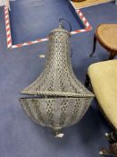 A large pierced metal ceiling shade