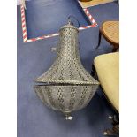 A large pierced metal ceiling shade