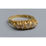 An Edwardian 18ct gold and graduated five stone diamond set half hoop ring, size P/Q, gross 4