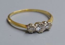 A yellow metal (tests as 18ct) and three stone diamond ring, size O, gross 2.2 grams.CONDITION: