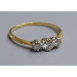 A yellow metal (tests as 18ct) and three stone diamond ring, size O, gross 2.2 grams.CONDITION: