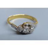 An 18ct and illusion set three stone diamond crossover ring, size R, gross 3.2 grams.CONDITION: