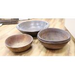 Three large treen bowls, largest diameter 47cmCONDITION: All three bowls have splits and blemishes