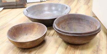 Three large treen bowls, largest diameter 47cmCONDITION: All three bowls have splits and blemishes