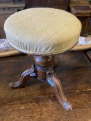 A Victorian revolving mahogany adjustable piano stool