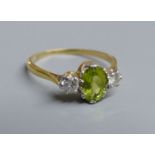 An 18ct and plat. peridot and diamond set three stone ring, size N, gross 2.5 grams.CONDITION: