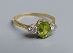 An 18ct and plat. peridot and diamond set three stone ring, size N, gross 2.5 grams.CONDITION: