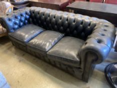 A Fleming & Howland, Chesterfields buttoned black leather three seater Chesterfield settee, length