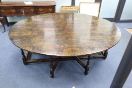 A late 17th century style oak oval topped, double gate leg dining table, width 214cm depth 180cm (