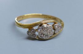 A 1940's? 18ct, plat and diamond set heart and flower head shaped triple cluster crossover ring,