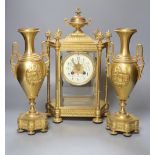 A late 19th century French garniture de cheminée comprising a four-glass mantel clock and a pair