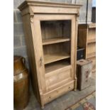 A pine display cabinet, fitted single glazed door enclosing four shelves over base drawer, width