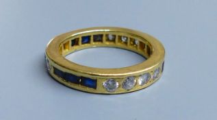 A modern yellow metal (tests as 18ct), sapphire and diamond set full eternity ring, size 0, gross