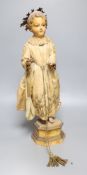 A late 19th century Continental carved and painted wood statue of a Saint, on a plinth base,