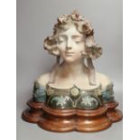 A pottery bust of a lady on a wooden stand, signed Jacobs, overall height 45cm