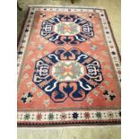 A peach ground rug centred by two stylised foliate blue ground medallions, 230 x 170cm