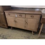 An Ercol elm sideboard (model no. 351), fitted one long drawer and one short drawer over three