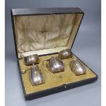 A cased George V silver five piece condiment set with two matching spoons, Walker & Hall, Sheffield,