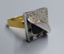 An unusual white metal, black onyx?, sapphire and diamond set square cluster ring, with planished '