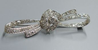 A white metal and millegrain set diamond cluster ribbon bow brooch, 54mm, gross 5.9 grams.CONDITION: