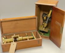 A 'hinge and wedge' compound microscope by Parkes & Son, Birmingham and a lacquered brass student'