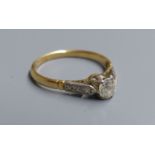 An 18ct and plat. single stone diamond ring, with diamond set shoulders, size I, gross 1.6 grams.