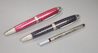 Two white metal and enamel roller ball Theo Fennell logo pens, one black and one pink, 14.4 x 10.4cm