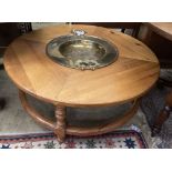 A circular pine low table inset two-handled brass brazier, diameter 108cm height 43cm