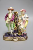 A 19th century Minton figural group and taper stick depicted as a lady and gentleman standing beside