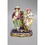 A 19th century Minton figural group and taper stick depicted as a lady and gentleman standing beside