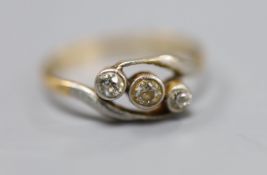 An 18ct and three stone diamond set crossover ring, size Q, gross 2.4 grams.CONDITION: Small nick to