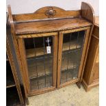 A 1920's oak bow front bookcase, length 73cm, width 26cm, height 110cm
