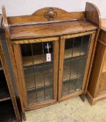 A 1920's oak bow front bookcase, length 73cm, width 26cm, height 110cm