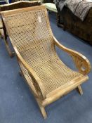 An early 20th century Anglo-Indian caned weathered teak armchair, width 57cm, depth 90cm, height