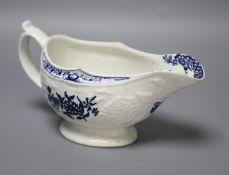 An 18th century Lowestoft floral moulded sauceboat flower in blue to each side and inside base,