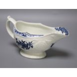 An 18th century Lowestoft floral moulded sauceboat flower in blue to each side and inside base,