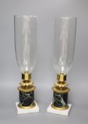 A pair of Regency style ormolu and marble candle lamps, height 48cm to glass storm