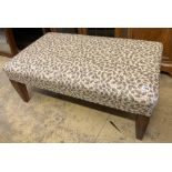 A modern rectangular footstool upholstered in a printed leaf fabric, width 90cm, depth 53cm,