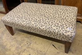 A modern rectangular footstool upholstered in a printed leaf fabric, width 90cm, depth 53cm,