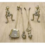 A set of three brass claw and ball fire implements and dogs