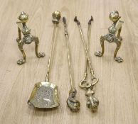 A set of three brass claw and ball fire implements and dogs