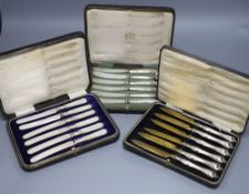 A cased set of six silver pistol handles tea knives(a.f.) and two other cased sets of knives.