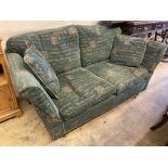 A modern contemporary upholstered two seater sofa upholstered in patterned green fabric, length