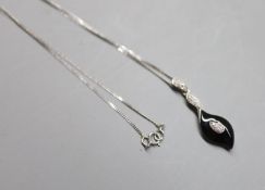 A modern 9ct white gold, black onyx and diamond chip set drop pendant, 31mm, on a 9ct white gold